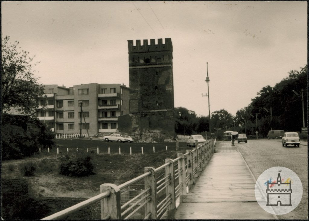 Zdjęcie przedstawia widok z mostu drogowego na Bramę Sztumską i fragment budynku mieszkalnego na Starym Mieście.