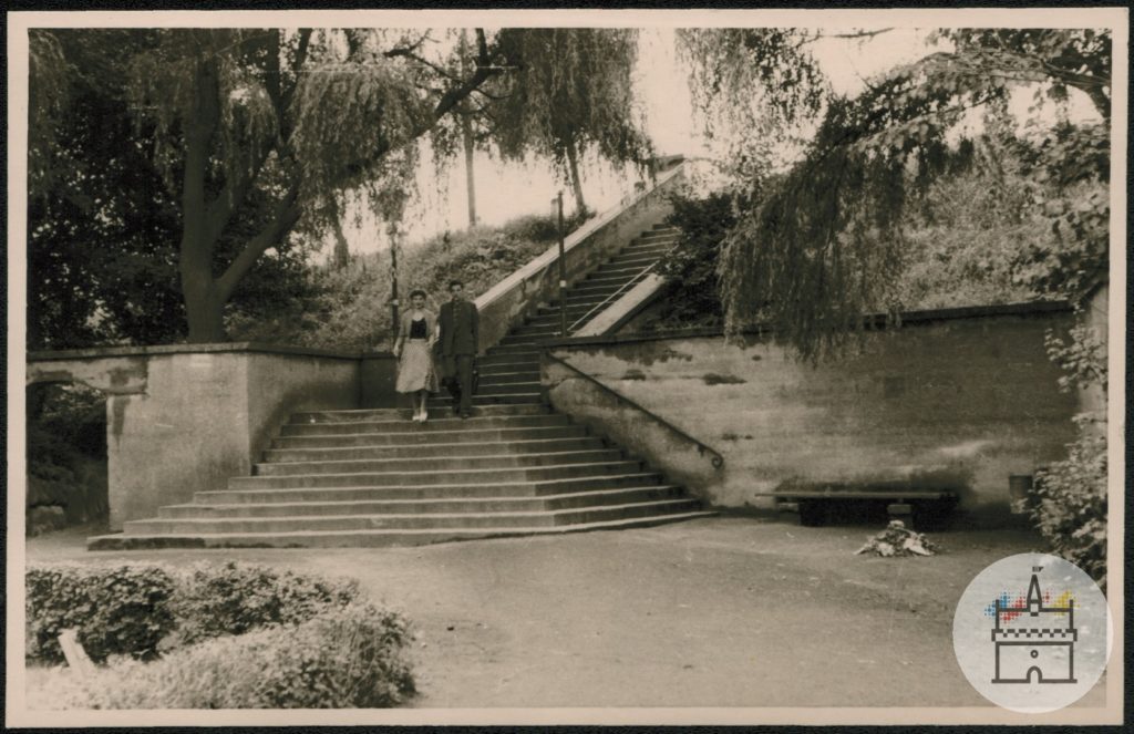 Fotografia przedstawia zejście ze starego wiaduktu do parku miejskiego.